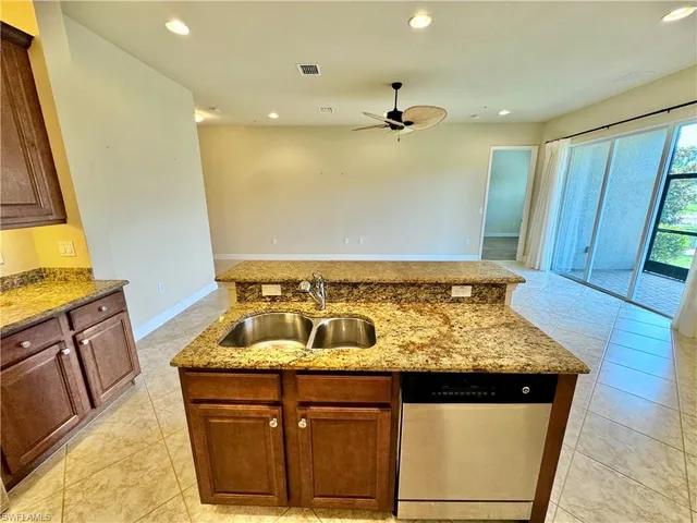a kitchen with a refrigerator sink and wooden cabinets