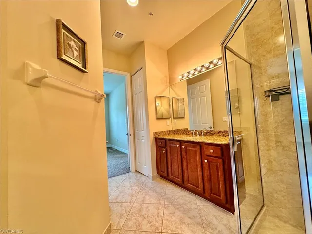 a bathroom with a granite countertop shower sink and mirror