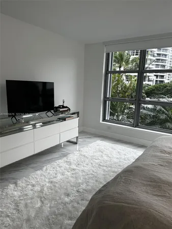 a view of an empty room with furniture and flat screen tv