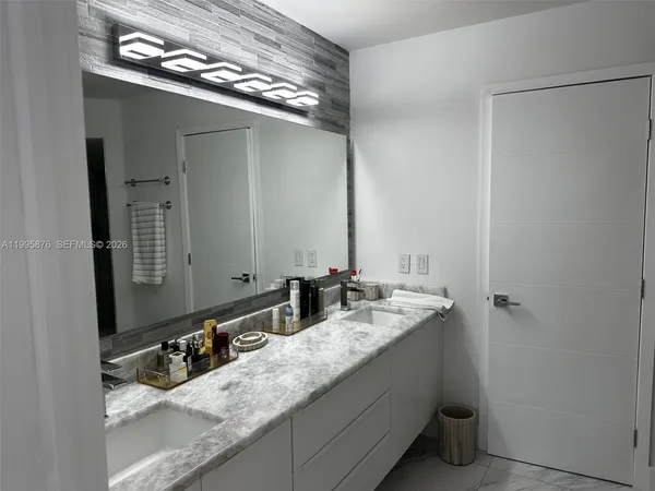 a bathroom with a granite countertop sink and a mirror
