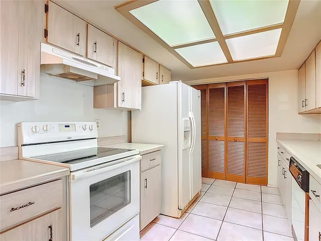 a kitchen with cabinets and steel appliances