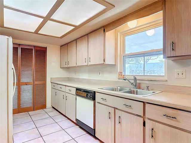 a kitchen with a sink window and cabinets