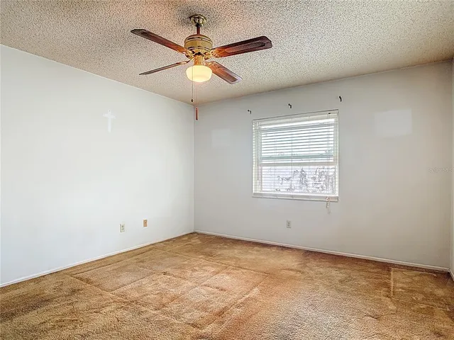an empty room with a window and a fan