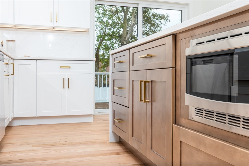 96 Burpee Road, Unit 1 Swampscott, MA 01907 - Photo 7 of 17 a view of a kitchen with white cabinets and a refrigerator