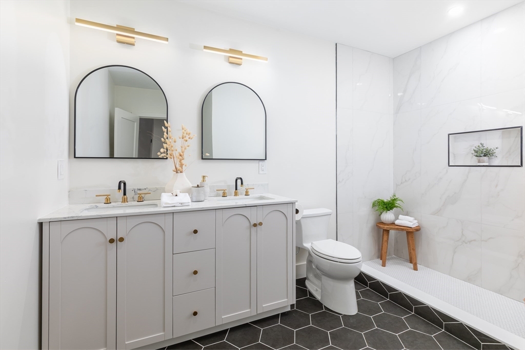 96 Burpee Road, Unit 1 Swampscott, MA 01907 - Photo 8 of 17 a bathroom with a granite countertop toilet a sink and a mirror