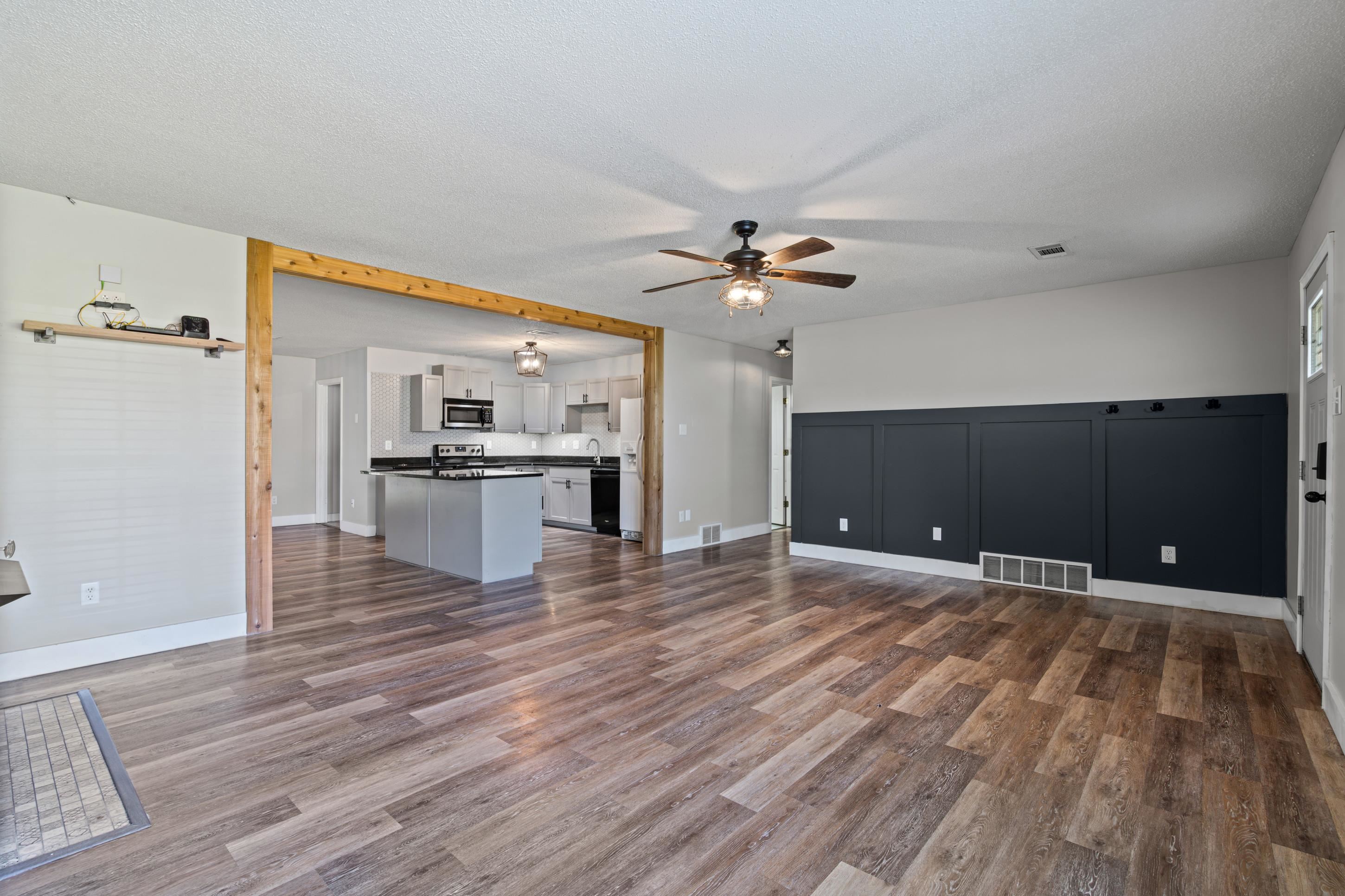 511 Rae Drive Munford, TN 38058 - Photo 4 of 30 a view of an empty room with wooden floor and a kitchen