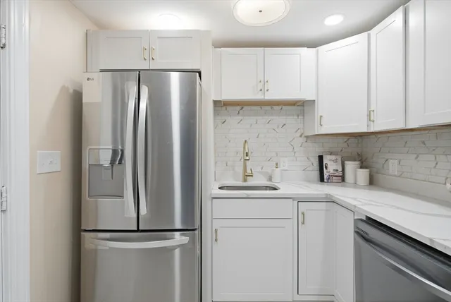 a kitchen with stainless steel appliances a refrigerator sink and cabinets