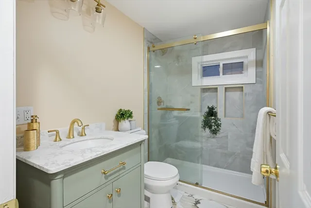 a bathroom with a granite countertop sink toilet and shower