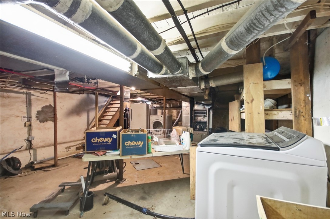 2591 Wayland Road Deerfield, OH 44411 - Photo 31 of 46 Concrete floor basement featuring exposed overhead ductwork, fluorescent lighting, a wooden staircase, and unfinished walls