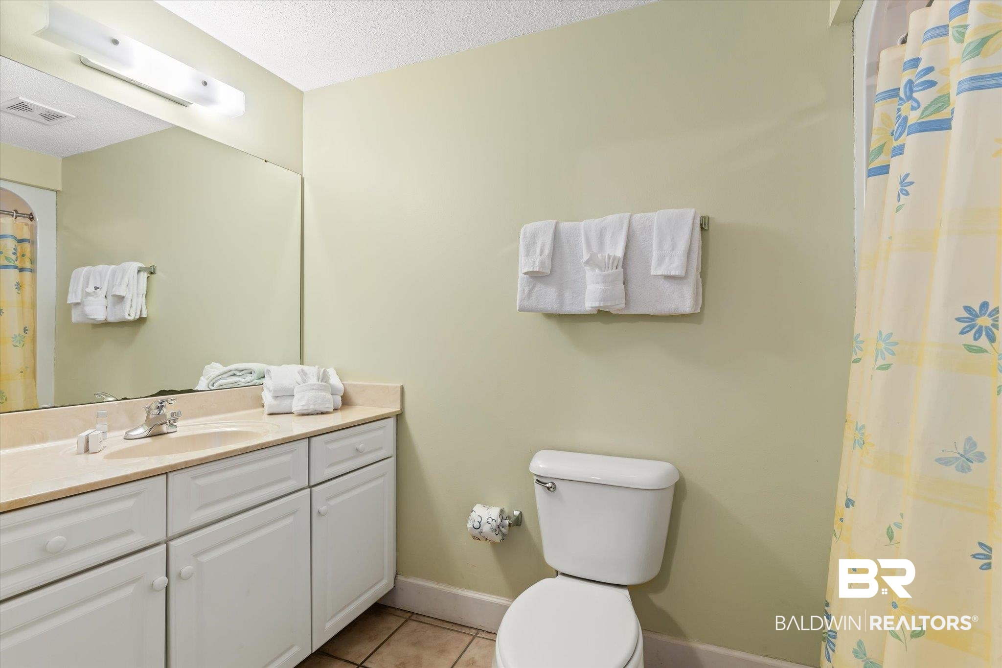 27580 Canal Road, Unit 1322 Orange Beach, AL 36561 - Photo 19 of 30 Bathroom with tile patterned flooring, toilet, a shower with curtain, vanity, and a textured ceiling