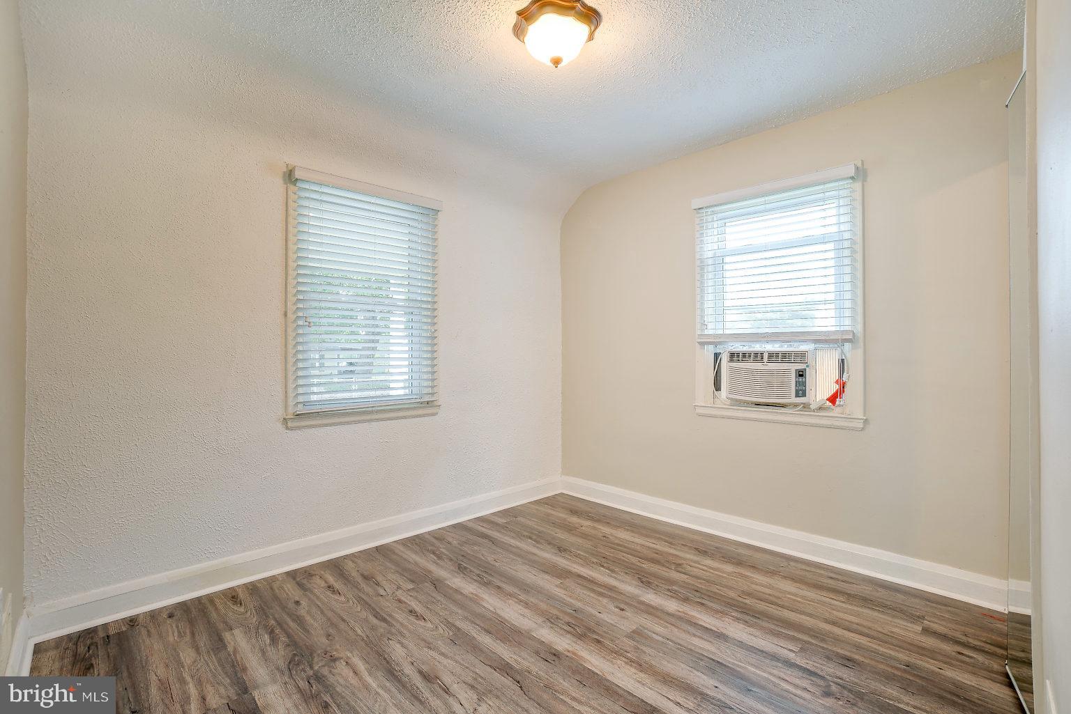 7708 Fairgreen Road Baltimore, MD 21222 - Photo 13 of 44 a view of an empty room with wooden floor and a window