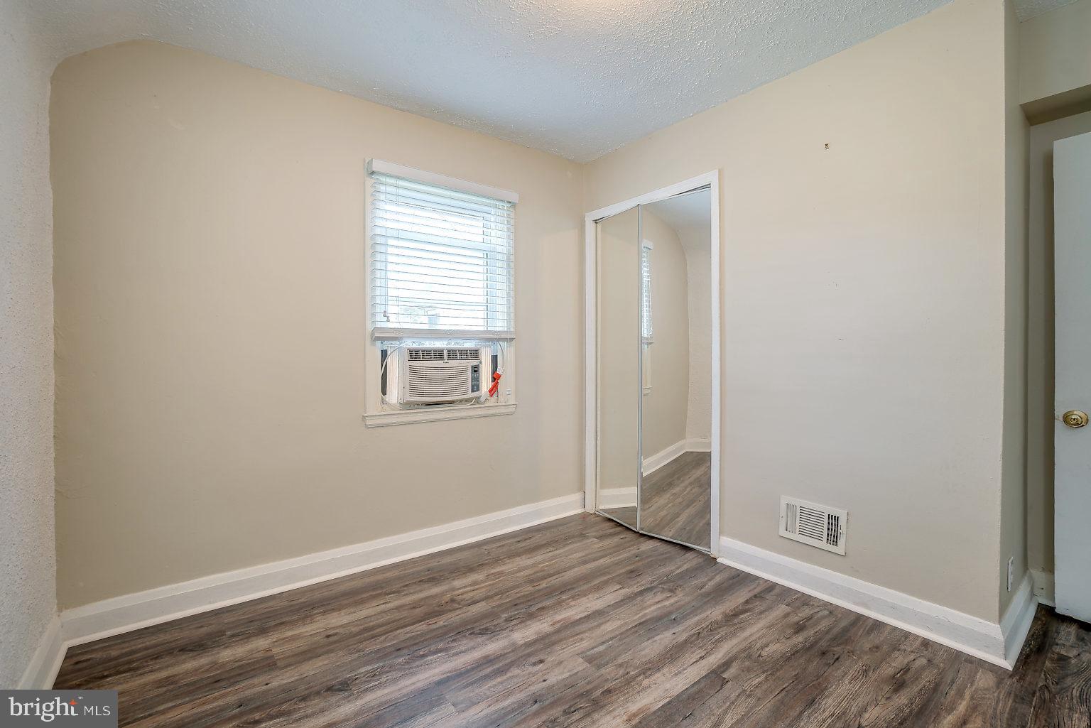 7708 Fairgreen Road Baltimore, MD 21222 - Photo 14 of 44 an empty room with wooden floor and windows