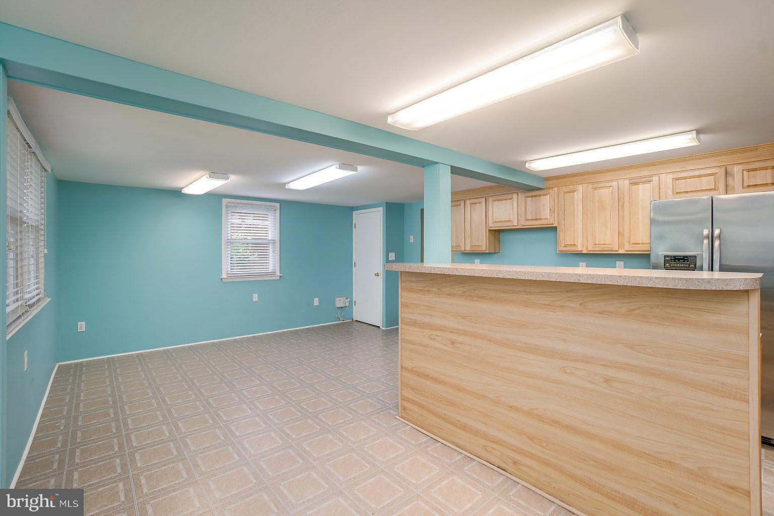 7708 Fairgreen Road Baltimore, MD 21222 - Photo 33 of 44 a view of a kitchen with kitchen island a sink wooden floor and a large window
