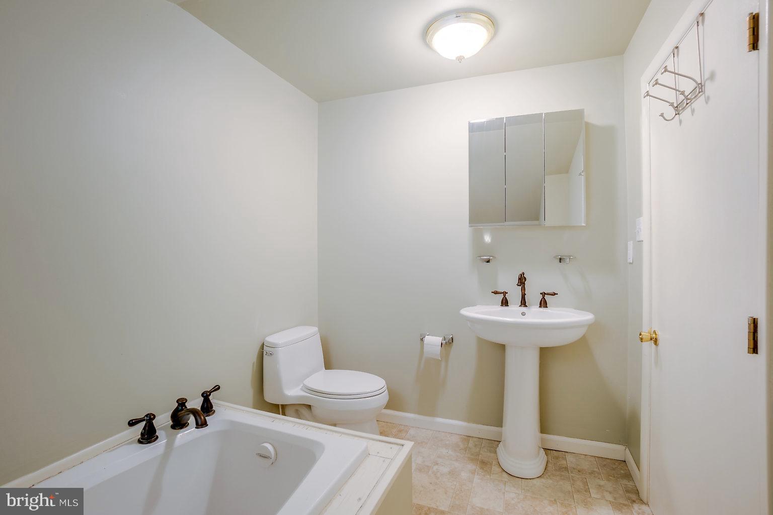 7708 Fairgreen Road Baltimore, MD 21222 - Photo 42 of 44 a bathroom with a sink a toilet and mirror