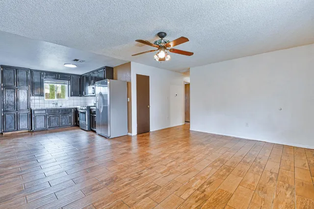 a view of an empty room with window and wooden floor