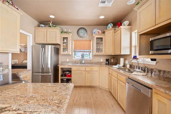 a kitchen with refrigerator cabinets and wooden floor