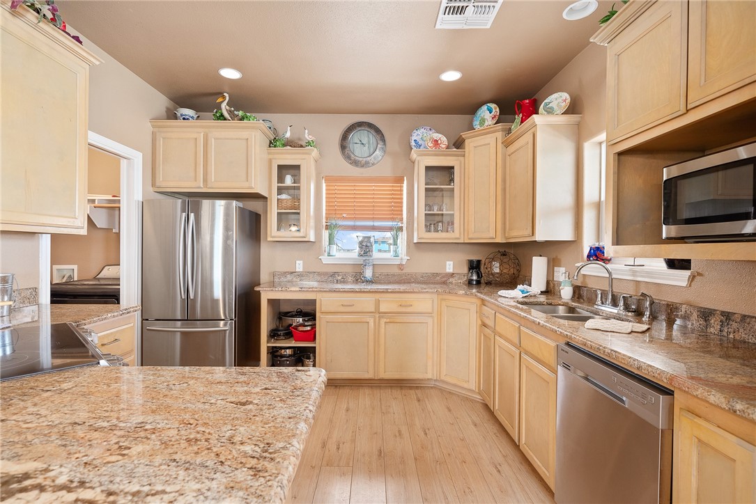 384 Egery Island Road Woodsboro, TX 78393 - Photo 11 of 37 a kitchen with refrigerator cabinets and wooden floor