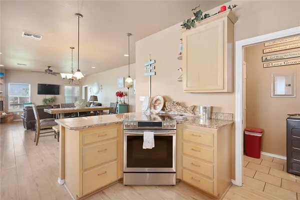 a kitchen that has a lot of white cabinets and stainless steel appliances