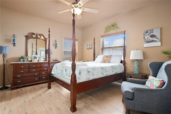 a bedroom with a bed a chandelier and a window