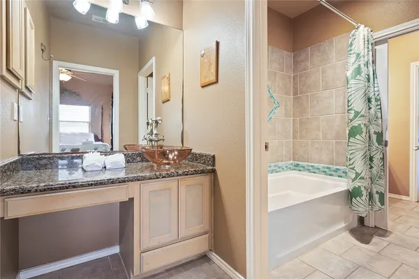a bathroom with a granite countertop sink a mirror and bathtub