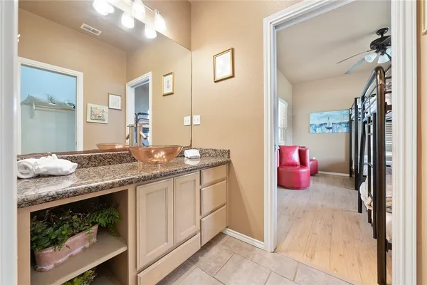a bathroom with a granite countertop sink and a mirror
