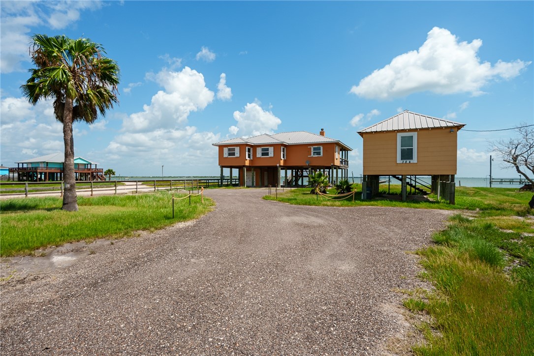 384 Egery Island Road Woodsboro, TX 78393 - Photo 3 of 37 a front view of a house with a yard and palm trees