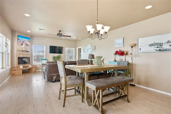 a view of a dining room with furniture a chandelier and wooden floor