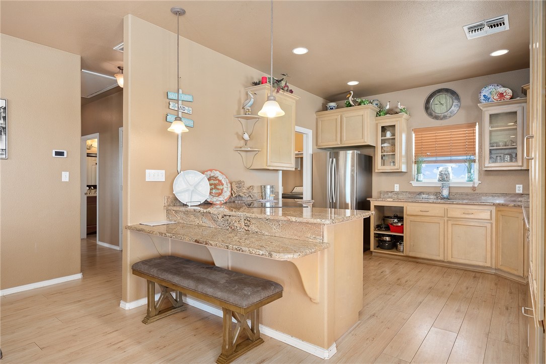 384 Egery Island Road Woodsboro, TX 78393 - Photo 10 of 37 a kitchen with refrigerator cabinets and wooden floor