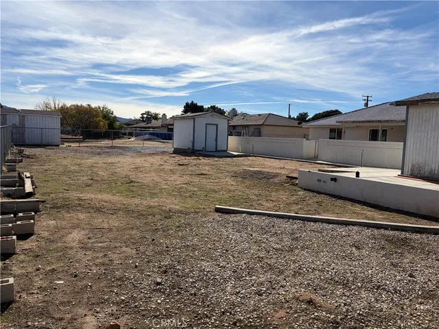 a view of a dry yard with wooden fence