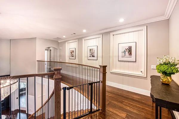 a view of a hallway with wooden floor and windows