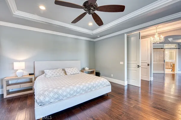 a bedroom with a bed and a chandelier
