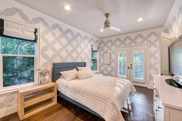 a bedroom with a balcony a bed and a flat screen tv