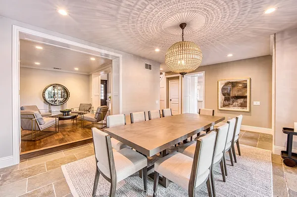 a view of a dining room and livingroom with furniture wooden floor and a chandelier