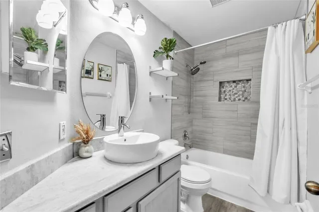 a bath room with a toilet a sink and a bath tub