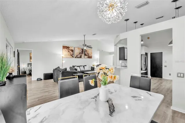a kitchen with stainless steel appliances kitchen island granite countertop a table and chairs in it