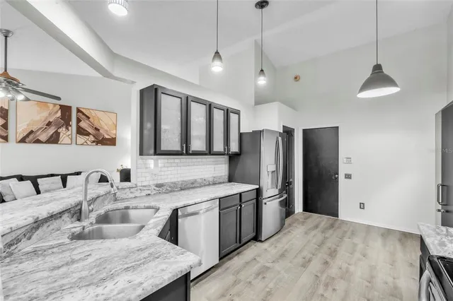 a kitchen with stainless steel appliances granite countertop a sink refrigerator and cabinets