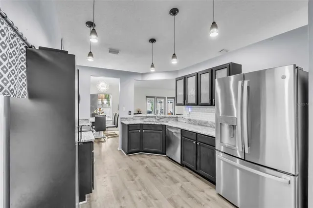 a large kitchen with cabinets and stainless steel appliances