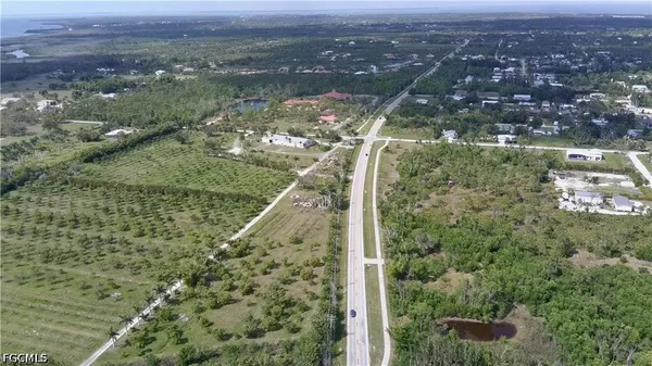 an aerial view of residential houses with outdoor space and trees