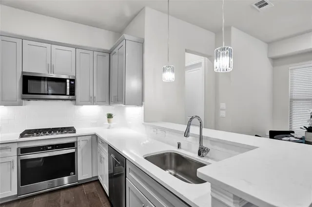 a kitchen with a sink and stainless steel appliances