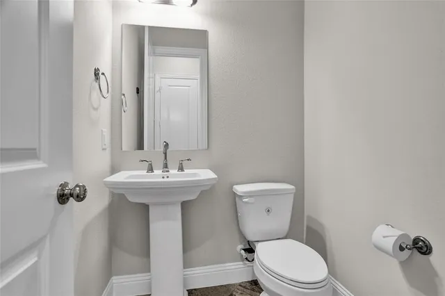 a bathroom with a toilet a sink and mirror