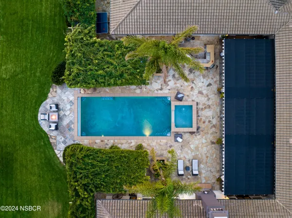 a view of swimming pool with seating area and trees in the background