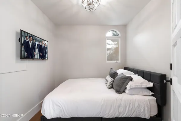 a bedroom with a bed and a large window
