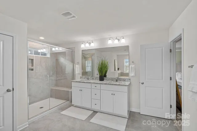a bathroom with a granite countertop sink mirror and shower