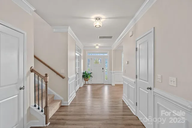 a view of a hallway with wooden floor and staircase
