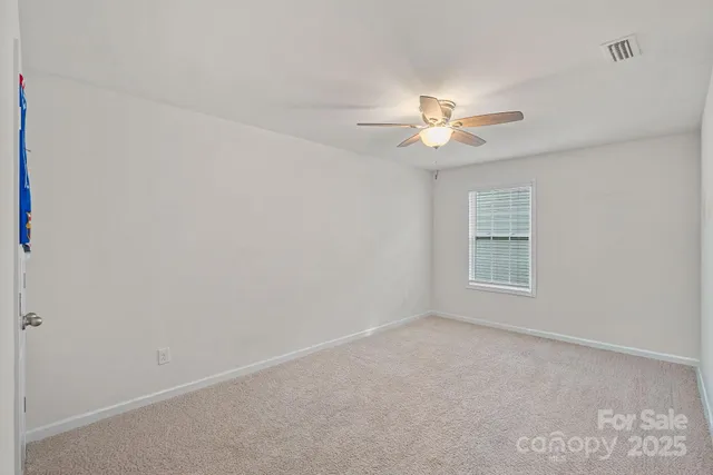 a view of a room with a ceiling fan and a window
