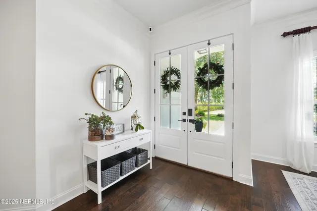 a bathroom with a sink a mirror and a potted plant