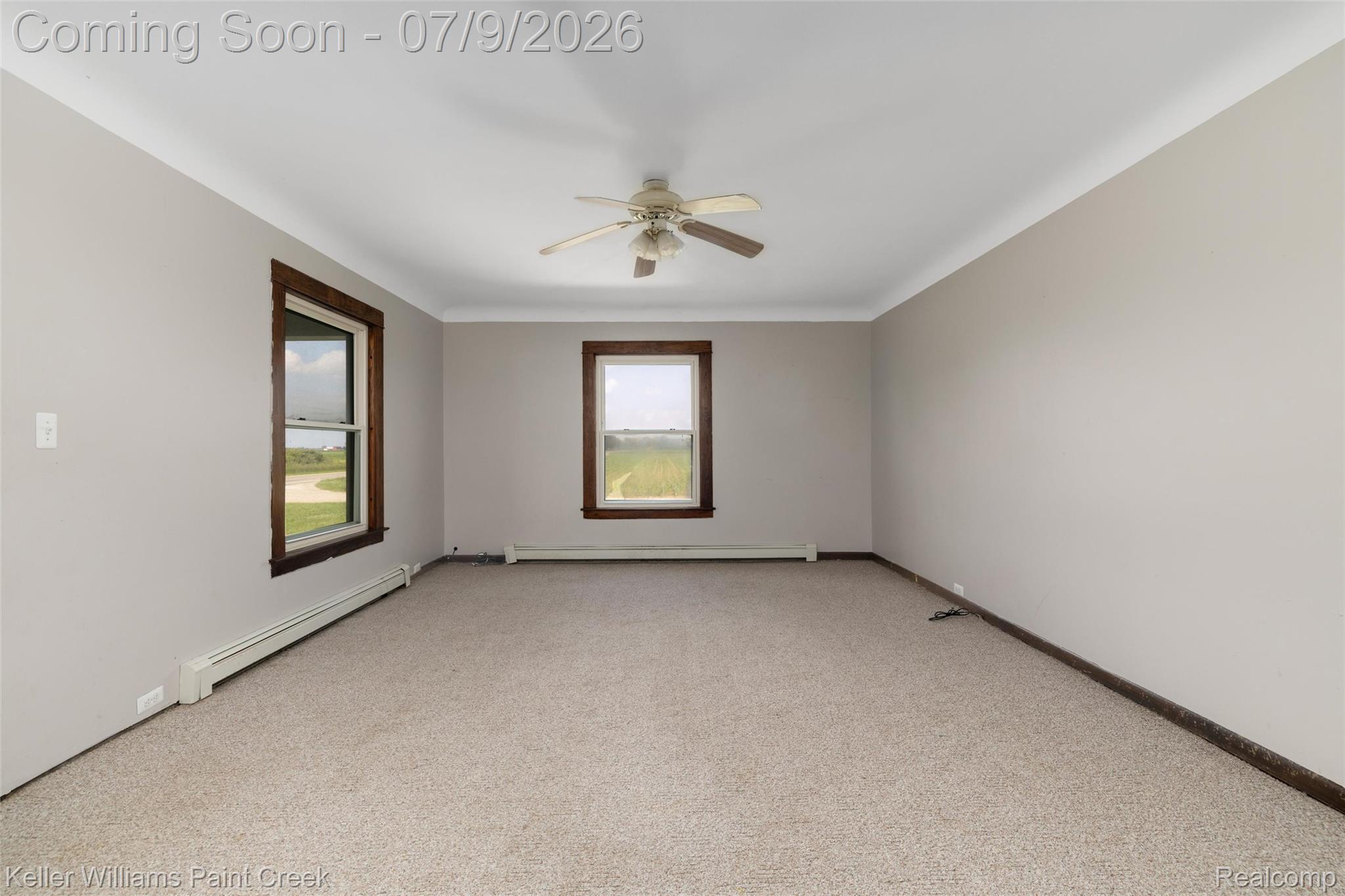 28780 School Section Road Richmond, MI 48062 - Photo 4 of 50 Spacious room featuring neutral carpeting, light gray walls, white crown molding, and two windows with wood-trim framing