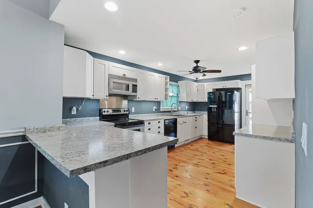 a kitchen with stainless steel appliances granite countertop a sink stove and refrigerator