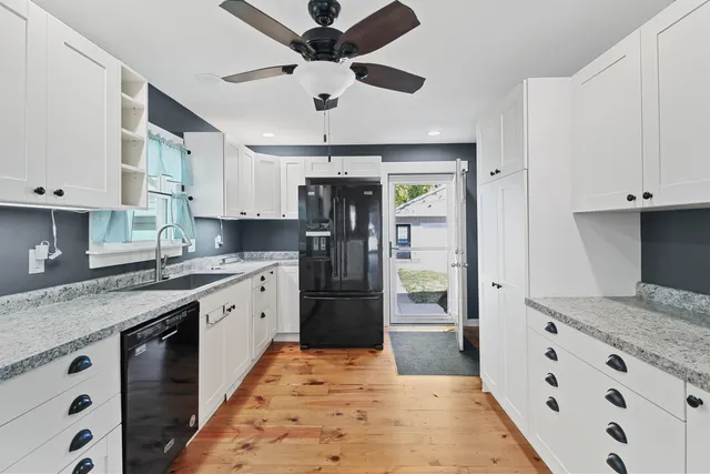 a kitchen with granite countertop a refrigerator and a sink