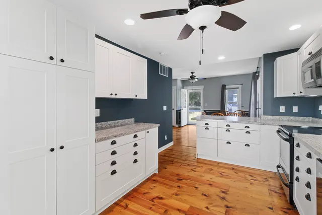 a kitchen with granite countertop a sink cabinets stainless steel appliances and a counter top space